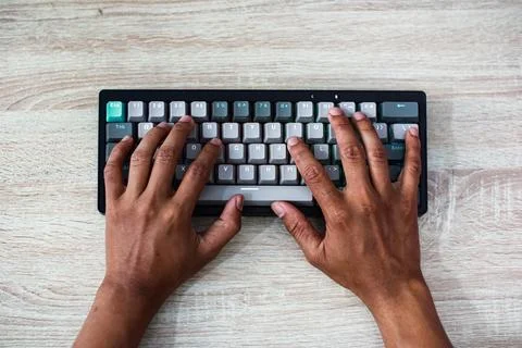 Overhead View of Hands Typing on a Gray and White Keyboard Foto stock
