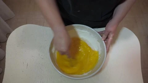 Overhead view of hands whisking eggs with flour Vidéo 342361754