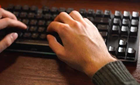 An overhead view of the hands of a young programmer working on a keyboard o.. 스톡 사진