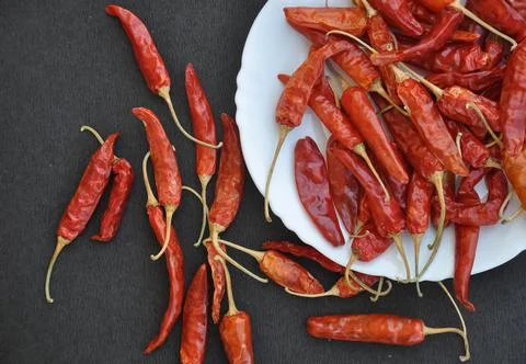 Overhead view of heap of red chilli peppers in white plate Stock Photos