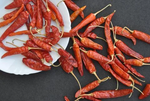 Overhead view of heap of red chilli peppers in white plate  Stock Photos
