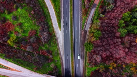 Overhead view of highway interchange with trucks in autumn woodland, Bulgaria Stock Footage 336728070