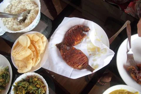 Overhead view of a Indian meal of fried fish, vegetables and breads. Stock Photos