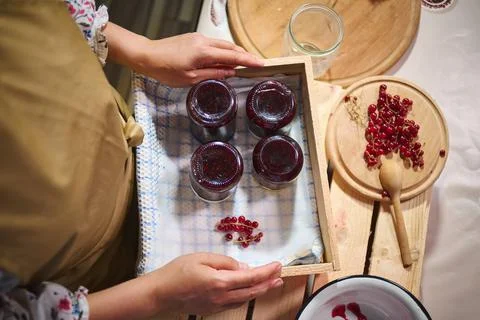 Overhead view of jars with red currant jam stacked upside down on a wooden crate Stock Photos