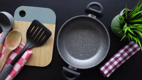 Overhead view of kitchen utensils and cooking pot on black table dynamic mo.. Stock Footage 333029965