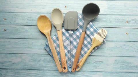 Overhead view of kitchen utensils arranged on a blue wooden table with a ch.. Stock Footage 333033243