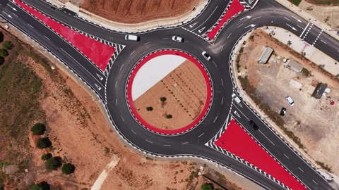 Overhead view of a large circular roundabout with red painted zones and white Stock Footage 335475989