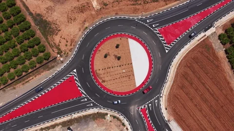 Overhead view of a large circular roundabout with bold red painted markings Stock Footage 341466644