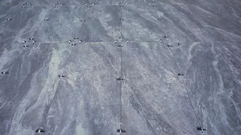 Overhead view of large gray marble tiles with subtle veining and metal fast.. Stock Photos