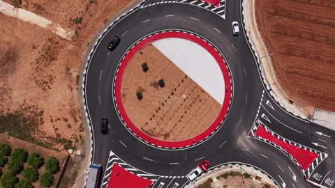 Overhead view of a large roundabout with bold red markings and white dashed Stock Footage 336741528