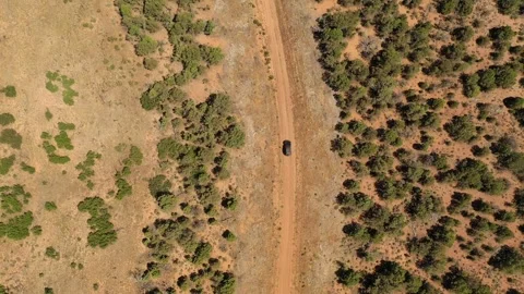 Overhead view looking down on a Jeep as it drives on a country dirt road Stock Footage 247674118