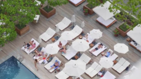 Overhead view of a luxury poolside with relaxing guests in 4k slow motion 60f Stock Footage 279944130