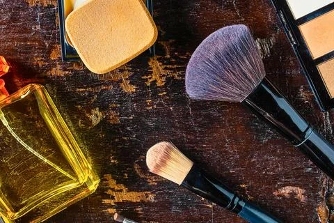Overhead view of makeup brushes and cosmetics on a textured surface Stock Photos