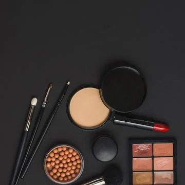 Overhead view makeup products with brushes black backdrop Stock Photos