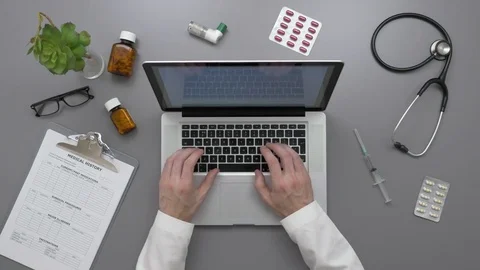 Overhead View Of Male Doctor Using Laptop At Desk Stock Footage 79649838