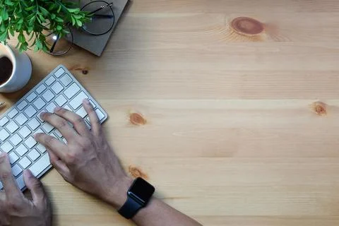 Overhead view man freelancer hands typing on wireless keyboard. Stock Photos