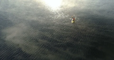 Overhead View Of Man Kayaking On A Lake In The Mist At Sunrise Video stock 101001928