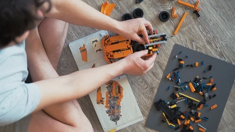 Overhead view of man in lotus pose constructing a car model Stock Footage 127888367