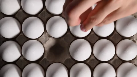 Overhead view of a man selecting a white egg from a box for his recipe. 動画素材 318850377