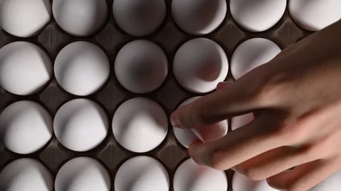 Overhead view of a man selecting a white egg from a box for his recipe. 스톡 동영상 318850487