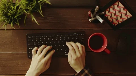 Overhead view of man using keyboard and drinking tea Stock Footage 81174255