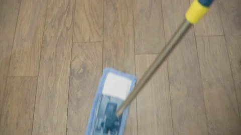 Overhead view of a microfiber mop pad being used for cleaning a wooden floor. Stock Footage 217353814