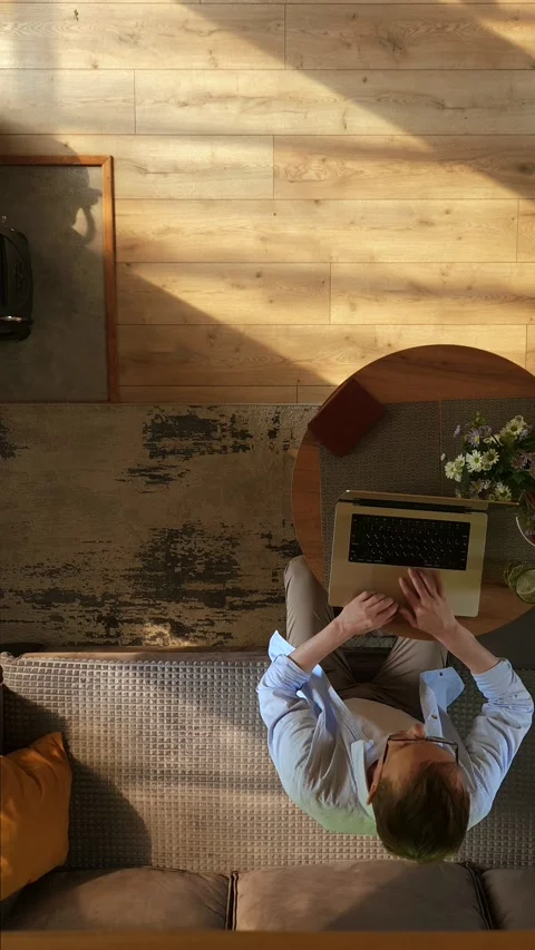 Overhead view of middle-aged man stops working on his laptop gets up from c.. Stock Footage 339135854