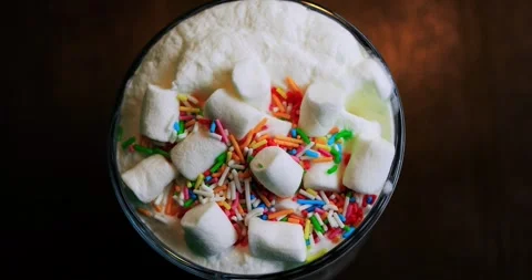 Overhead view of milkshake showcasing marshmallow assortment and silky foam Stock Footage 311751093