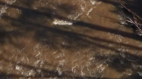 Overhead view of a muddy river flowing rapidly through a forest Stockbeeldmateriaal 336360876