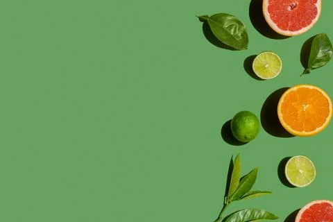 Overhead view on a orange, lime, grapefruit and leaves lying on a green backg Stock-Fotos