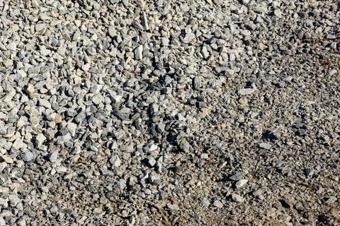 Overhead view of partially compacted crushed stone base with exposed soil at Stock Photos
