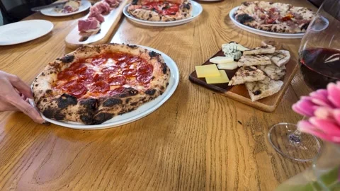 Overhead View of Pepperoni Pizza and Italian Appetizers on Wooden Table Stock Footage 337394754