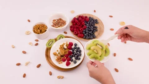 Overhead View of Person Adding Sliced Kiwi to Greek Yogurt Bowl Stock Footage 337875588