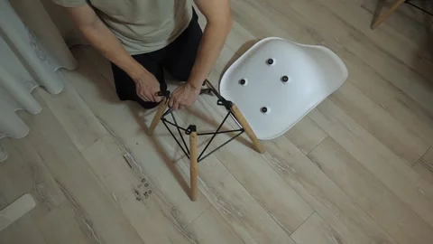 Overhead view of person assembling modern wooden leg chair Stock Footage 340015968
