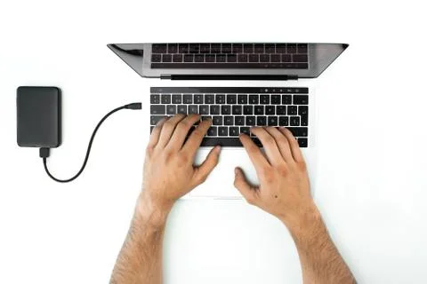 Overhead view of a person using his laptop on a white table. Modern workplace Stock Photos