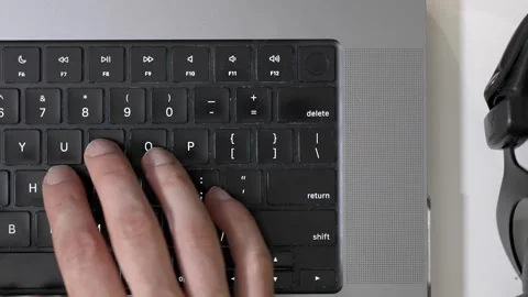 Overhead view of person working on laptop keyboard with headphones Stock Footage 336435966