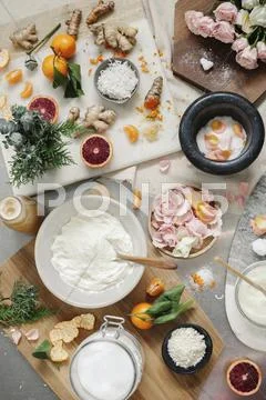 Overhead view of a pestle and mortar and rose petals, ginger and oranges Stock Photos