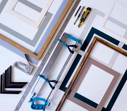 Overhead view of picture frames with work tools on table in workshop Stock Photos