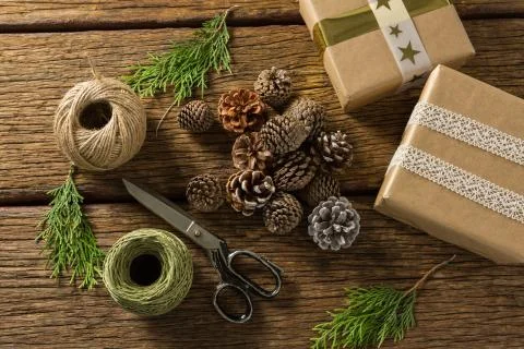 Overhead view of pine cones with gift boxes and thread spools Foto stock