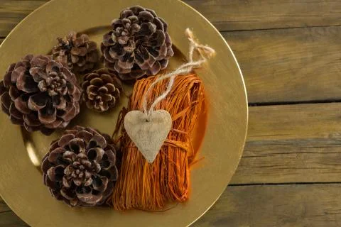Overhead view of pine cones with thread in plate Stock Photos