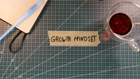 Overhead view of placing GROWTH MINDSET tape sticker near coffee and journal Stock Footage 338183739