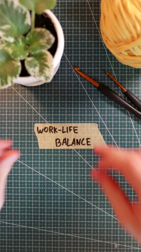 Overhead view of placing WORK-LIFE BALANCE tape near yarn and flowerpot Stock Footage 338183603