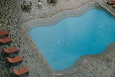Overhead view of a pristine pool area with lounge chairs and tables Stock-Fotos