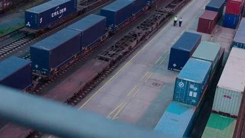 Overhead View of Rail Workers Walking Between Shipping Containers at Intermodal Stock Footage 334053530
