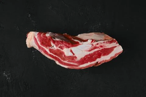 Overhead view of raw beef brisket on wooden cutting board 库存照片