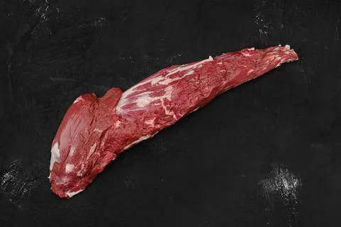 Overhead view of raw beef tri-tip loin on black background Foto stock
