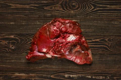 Overhead view of raw deer boneless ham over wooden background Foto stock