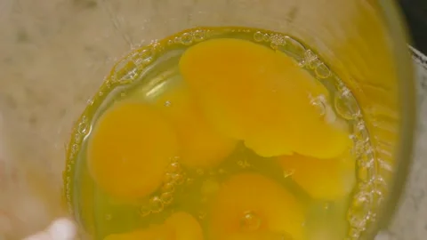 Overhead View of Raw Eggs Being Poured in Slow Motion into Measuring Jug with Stock Footage 308002674