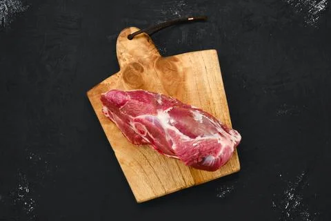 Overhead view of raw lamb rump on wooden cutting board Stock-Fotos
