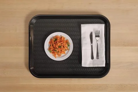 Overhead view of a rectangular black cafeteria tray holding a small white p.. Stock Photos